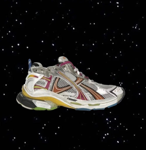 A chunky, multicolored Balenciaga Runners athletic sneaker with a layered mesh and synthetic design, set against a starry black background.