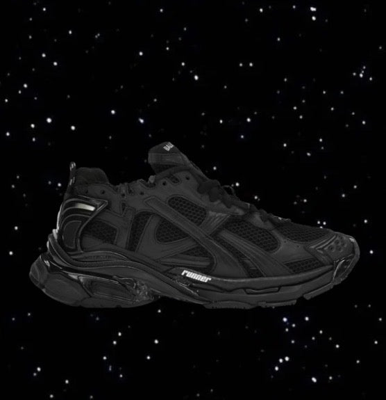 Black Balenciaga Runners with a mesh upper and chunky sole set against a black starry background.